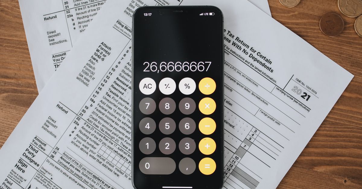 Mobile calculator app on tax documents, highlighting financial calculations and tax preparation.