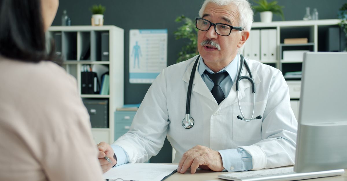 Experienced doctor consulting a patient in a medical office setting.