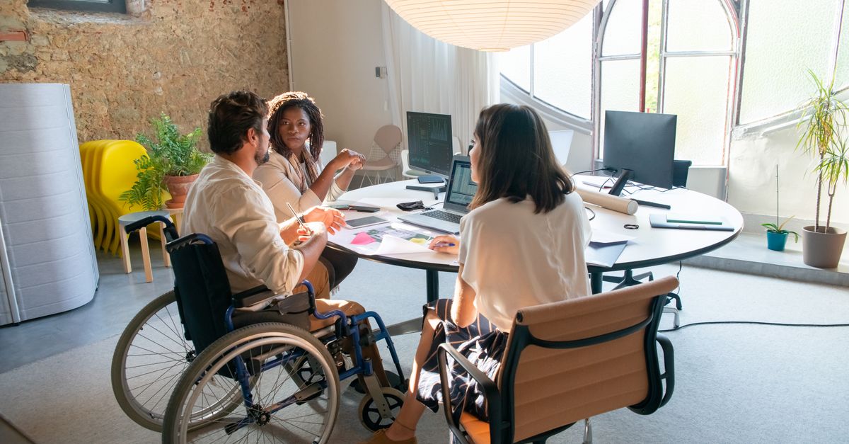 A diverse group of coworkers collaborating in an accessible office environment with a focus on inclusivity.