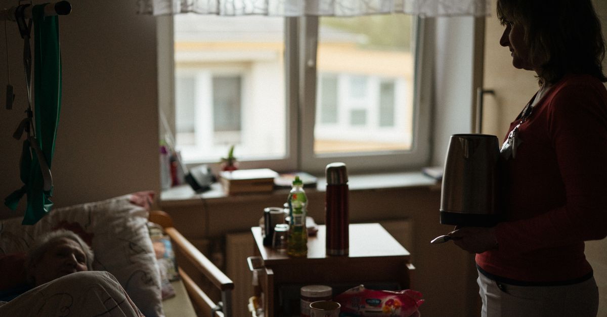 A caregiver prepares a warm drink for a senior in a peaceful retirement home setting.