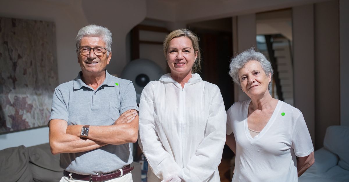 Group portrait of caregivers with senior adults in a home setting.