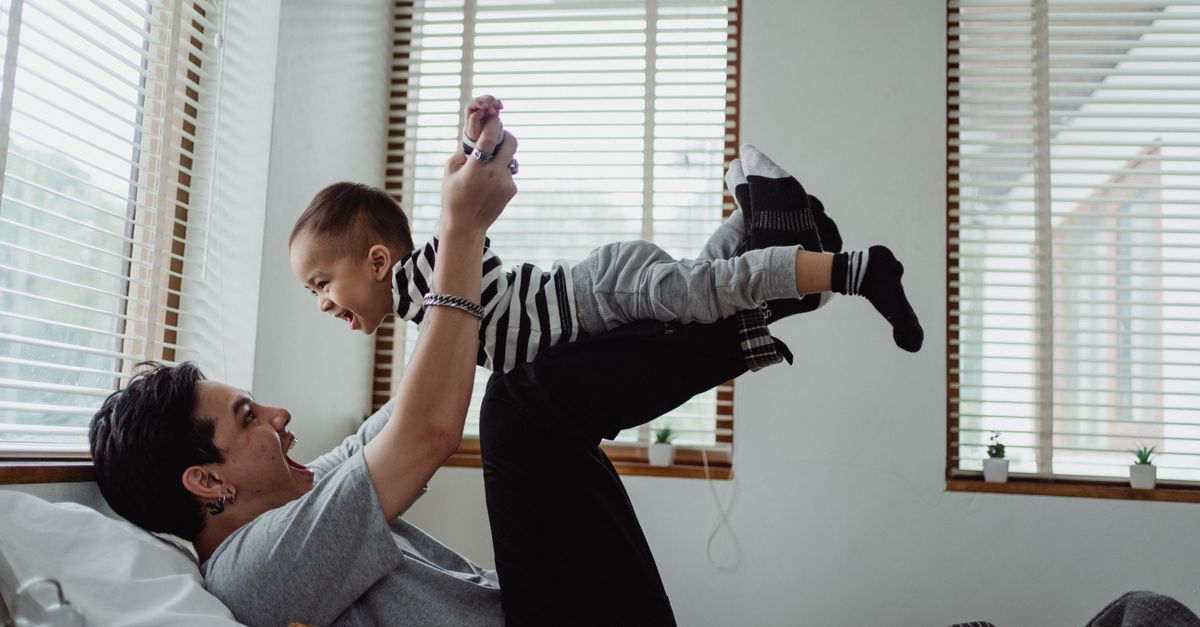 Dad and son enjoying playtime indoors. Joyful bonding moment.