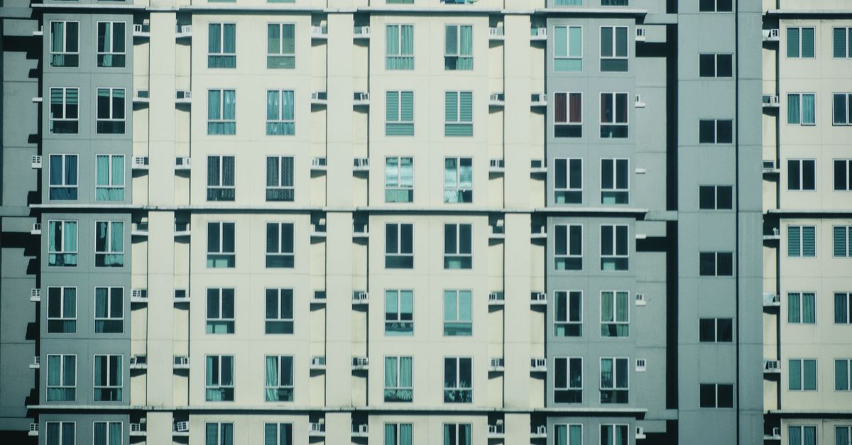 Symmetrical view of a modern urban residential building facade with geometric window patterns.